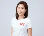 Person smiling, wearing a white T-shirt with SCI logo