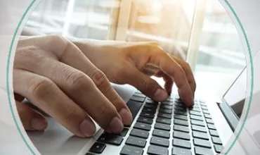 Hands typing on a laptop keyboard