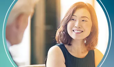 Two people having a conversation, focus on the smiling person.