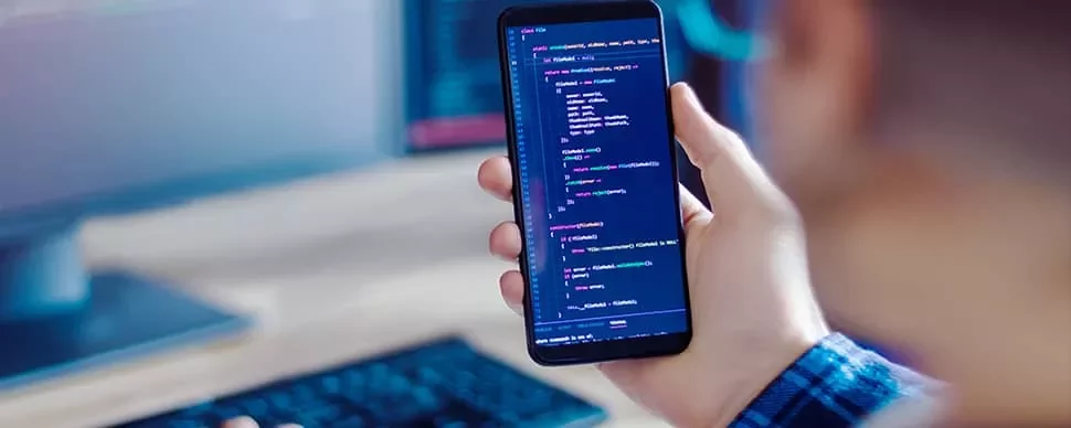 Person holding a smartphone displaying code.