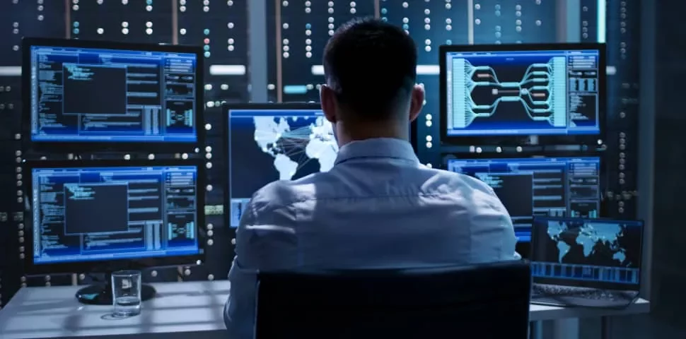 Person working with data on computer screens in a modern office