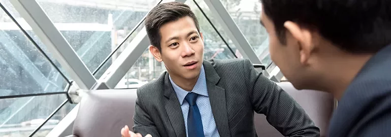 Two people having a conversation in an office.