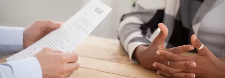 Close-up of a person holding a resume during an interview.