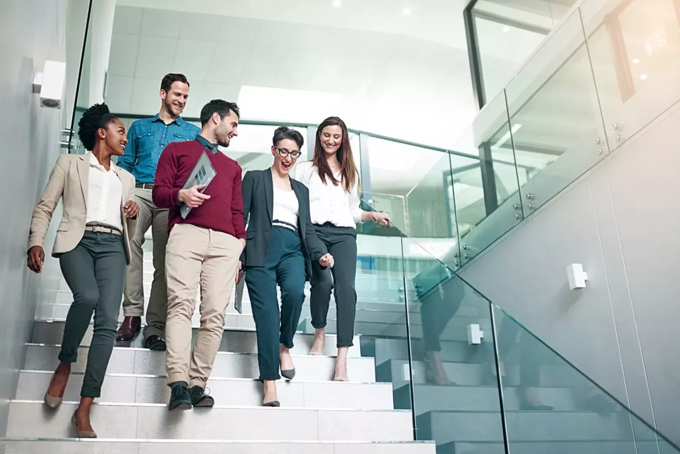 Colleagues walking and chatting on office stairs.