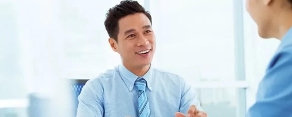 Two people having a conversation in a bright office.