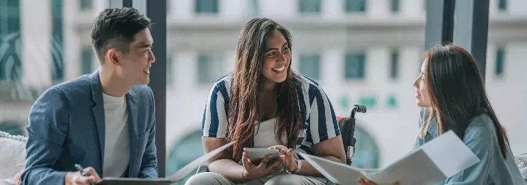 Three people having a discussion in an office
