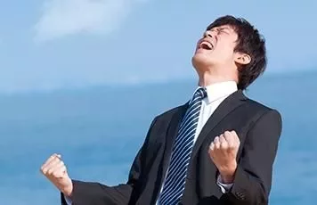 一名身穿西裝的人在戶外，雙拳緊握，看上去非常高興。