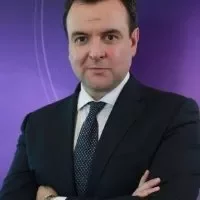 Person in a suit with a purple background.